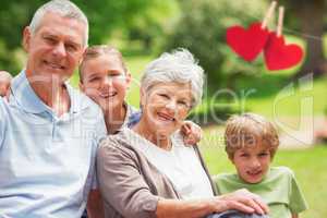 Composite image of smiling senior couple and grandchildren at pa