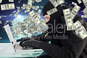 Composite image of robber sitting at desk hacking a laptop