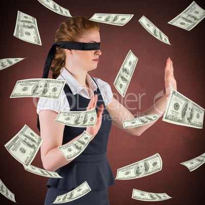 Composite image of redhead businesswoman in a blindfold