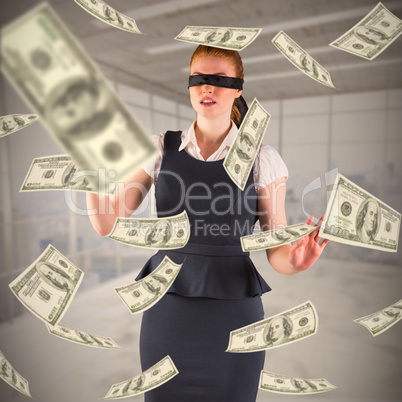 Composite image of redhead businesswoman in a blindfold