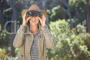 Smiling woman using binoculars