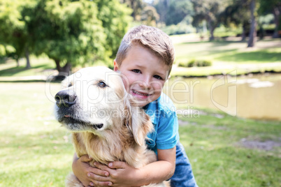 Smiling boy with his pet dog in the park