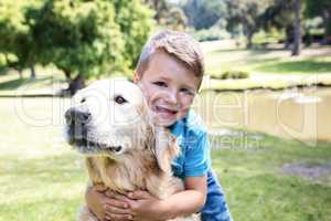 Smiling boy with his pet dog in the park