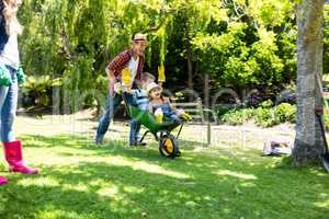 Father carrying his son and daughter in a wheelbarrow