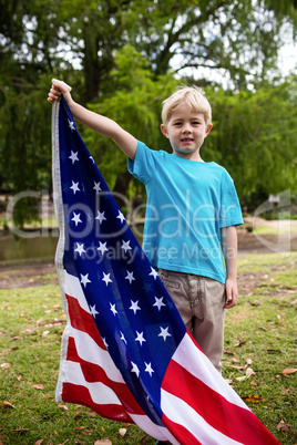 Boy holding an american flag in the park