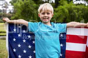 Boy holding an american flag in the park