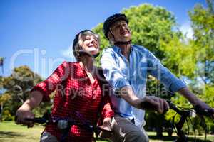 Happy couple riding a bicycle in park