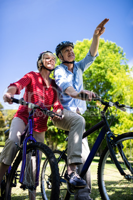 Senior couple standing with bicycle