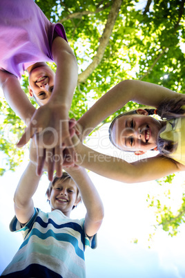 Portrait of happy children putting their hands together