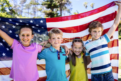 Children holding american flag in park