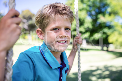 Boy sitting on a swing in the park