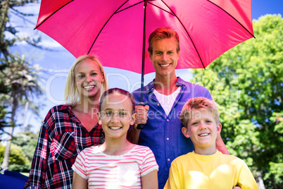 Family standing under umbrella