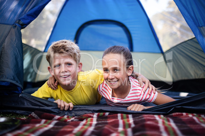 Siblings lying in a tent