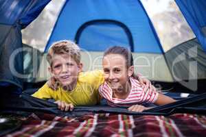 Siblings lying in a tent