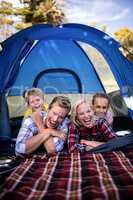 Happy family lying in a tent