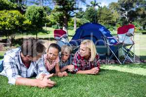 Family talking to each other while lying on grass