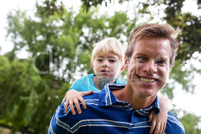 Portrait of father giving a piggy back to his son