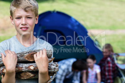 Boy carrying firewood outside the tent