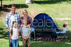 Portrait of a family standing outside the tent