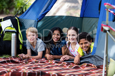 Portrait of children lying in a tent