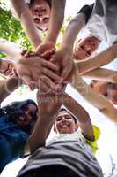 Portrait of happy children putting their hands together