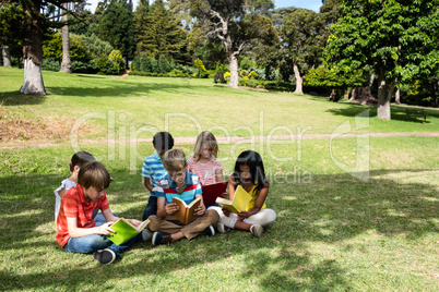 Children reading book in the park