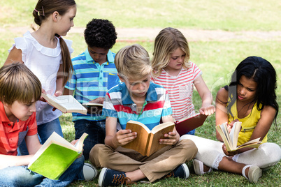 Children reading book in the park