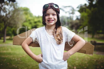 Happy girl standing in the park with hand on hip