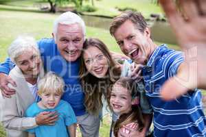 Multi-generation family posing for a selfie in the park