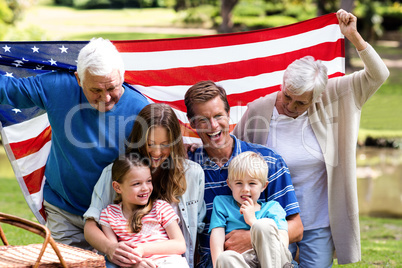 Multi-generation family holding american flag in the park