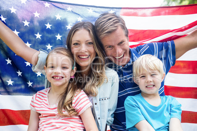 Hapy family holding american flag in the park