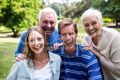 Portrait of happy family sitting together in the park