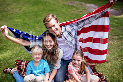 Hapy family holding american flag in the park