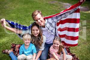 Hapy family holding american flag in the park