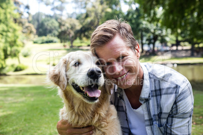 Smiling man with his pet dog in the park