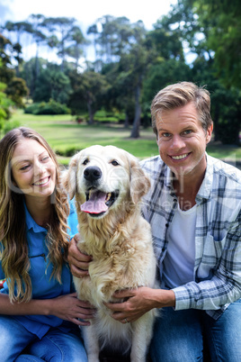 Couple sitting in the park with their dog