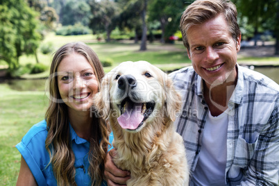 Couple sitting in the park with their dog