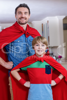 Father and son pretending to be superhero in living room