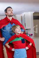 Father and son pretending to be superhero in living room