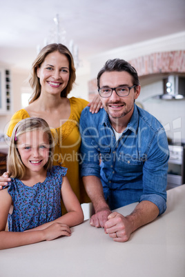 Portrait of happy parents and daughter in kitchen