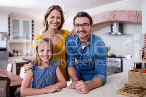 Portrait of happy parents and daughter in kitchen