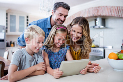 Parents and kids using digital tablet in kitchen Parents and kids using digital tablet in kitchen
