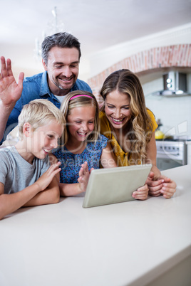 Parents and kids using digital tablet in kitchen