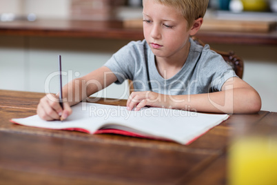 Boy doing homework in kitchen