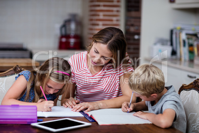 Mother helping kids with their homework