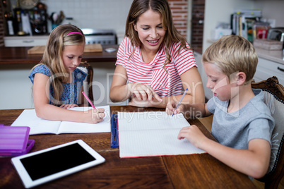 Mother helping kids with their homework