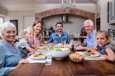 Multi-generation family having meal in kitchen