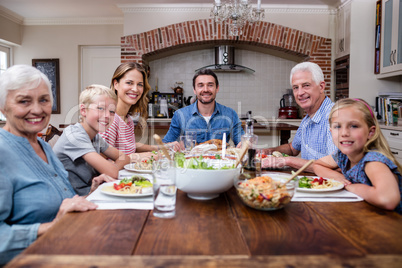 Multi-generation family having meal in kitchen