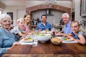 Multi-generation family having meal in kitchen