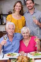 Portrait of a two generation family holding a wine glass at tabl